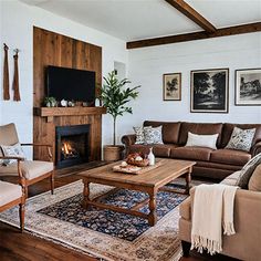 a living room filled with furniture and a fire place under a tv mounted on a wall