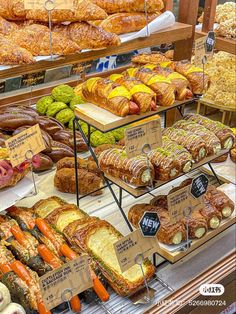 an assortment of breads and pastries on display in a bakery