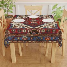 a table with two plates on it in front of some chairs and potted plants