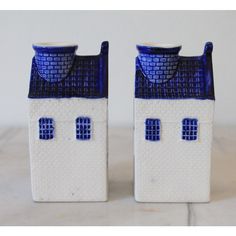 two blue and white ceramic houses sitting side by side