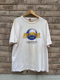 Vintage Hard Rock Cafe SkyDome Toronto 1989 T-shirt  Hanes Heavyweight tag Size XL 22.5 pit to pit  29 length Good condition   Be aware that these are used clothes and may have some blemishes, I have tried to disclose them as best as I can, please look at the pictures carefully! Reminder I am not responsible for packages lost in mail carrier as that is out of my control!  All Sales Are Final  Thanks for looking on 705Vintage Etsy page! For more follow our Instagram page- @705Vintage Hard Rock Cafe Sweater, Mail Carrier, Apa Aja, Rock Cafe, Hard Rock Cafe, Hard Rock, Toronto, Gender Neutral, That Look