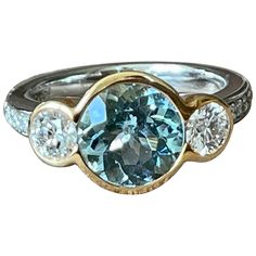 A timeless 18 K white Gold and rose Gold three Stone Ring featuring a bezel set Aquamarine wewighing approximately 2.50 ct. The centre stone is flanked by 2 bezel set brilliant cut Diamonds weighing 0.84 ct, G color, vs clarity. The ring size is currently a swiss 53/13 American Ring size 6 1/2, but can easily be resized. The ring is stamped with makers mark and 750. Masterfully handcrafted piece! Authenticity and money back is guaranteed. For any enquires, please contact the seller through the m Luxury Three Stone Gemstones For Anniversary, Luxury Three Stone Sapphire Ring, Luxury Bezel Set Gemstones For Formal Occasions, Luxury Formal Gemstones With Bezel Setting, Luxury Gemstones With Bezel Setting For Formal Occasions, Bezel Set Diamond Gemstones, Round Diamond Gemstones With Bezel Setting, Luxury Three Stone Round Cut Sapphire Ring, Luxury Bezel Set Round Ring