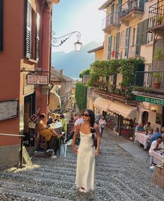 a woman walking down a cobblestone street