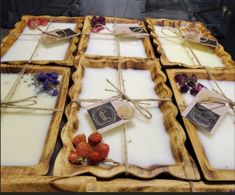 four wooden trays with candles and tags tied to them