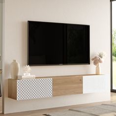 a flat screen tv mounted to the side of a white wall in a living room