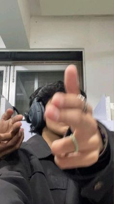 a man wearing headphones pointing at something