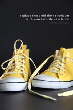 a pair of yellow shoes sitting on top of a black table next to a ribbon