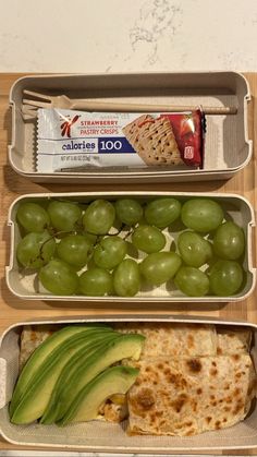 three trays filled with different types of food on top of a wooden table next to each other