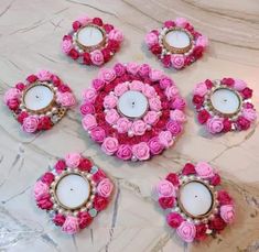 pink roses and candles are arranged on a marble table