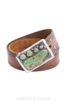 MAKE A CHIC, UNIQUE STATEMENT. This bold beauty is a showstopper! The vintage brown leather strap is embellished with a subtle scallop tooled border and it’s finished with a statement buckle boasting a specimen stone of turquoise accented by four smaller turquoise nuggets and sterling silver details. affiliation: likely Navajo materials: sterling silver, turquoise, vintage belt strap dimensions of buckle: 3" x 2" dimensions of strap: 32" - 36" weight: 73 grams nice vintage condition stones are s Vintage Leather Jewelry With Patina, Vintage Leather Jewelry With Strap, Vintage Brown Jewelry With Antique Buckle, Vintage Brown Leather Jewelry, Vintage Leather Jewelry With Concho, Vintage Turquoise Leather Jewelry, Belt Buckle Display, Buckle Display, Brand Lookbook