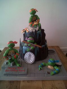 a birthday cake made to look like the teenage mutant turtles on top of each other