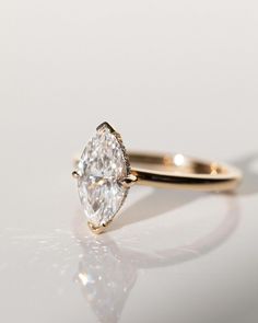 a close up of a diamond ring on a white surface