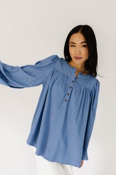 this retro-inspired long sleeve top will take you from summer picnics to fall photoshoots with ease. made with a dark wash denim-esque material, this elevated top features long balloon sleeves + a flowy silhouette. dress it up with trousers + heels, or down with white jeans + sandals. medium wash // high neckline, buttons, balloon sleeves, elastic cuffs paired with our camelot wide leg denim model is 5'8" + wearing a small measurements are approximate + taken while laying flat small : bust 42” l Relaxed Fit Denim Top For Fall, Spring Casual Puff Sleeve Blouse, Dark Wash Chambray Denim Top For Fall, Fall Dark Wash Chambray Denim Top, Spring Trendy Peasant Top With Puff Sleeves, Trendy Spring Peasant Top With Puff Sleeves, Fall Denim Puff Sleeve Top, Chambray Denim Top For Fall, Long Sleeve Tops With Elastic Sleeves For Day Out