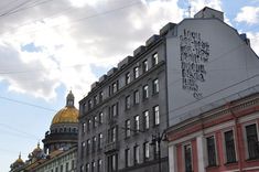 the building has many windows on it and is next to another building with a dome