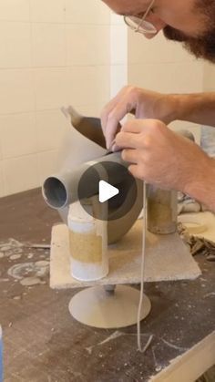 a man is making something out of clay