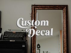 an old fashioned typewriter sitting in front of a mirror with the words custom decal over it