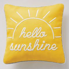 a yellow pillow with the words hello sunshine embroidered on it's front and back