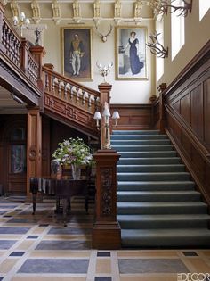 an elegant staircase with blue carpet and wooden handrails leads up to the second floor