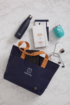 the contents of a travel bag laid out on a marble counter top, including an electronic device and other items