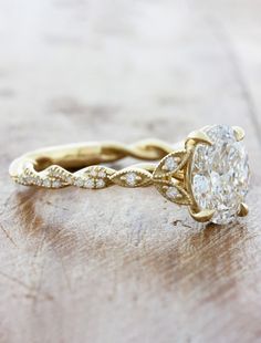 a close up of a diamond ring on a wooden surface