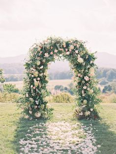 an outdoor wedding arch decorated with flowers and greenery