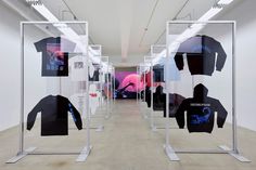 an art installation with multiple t - shirts on display in the middle of a room