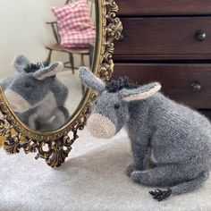 a stuffed donkey sitting in front of a mirror