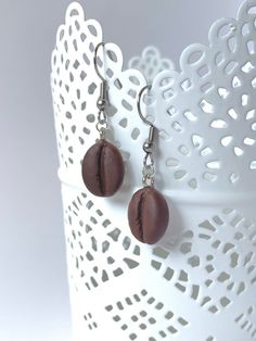 a pair of earrings with brown beads hanging from it's earwires on a white doily