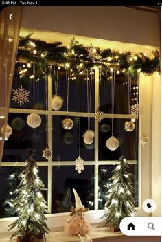 a window with christmas decorations hanging from it