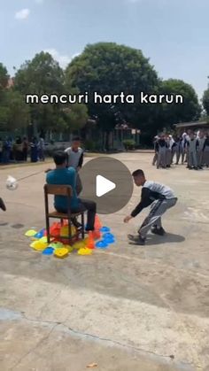 a group of people standing around each other on top of a cement ground with an object in front of them