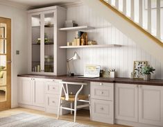 a home office area with white cabinets and shelves on either side of the desk, along with an open bookcase