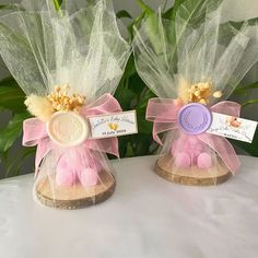 two small pink and gold angel decorations on top of a table