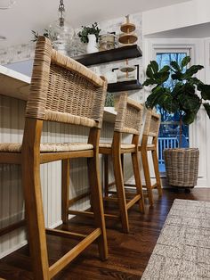 a row of wicker bar stools sitting on top of a hard wood floor