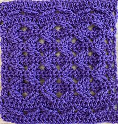 a purple crocheted square with holes in the middle