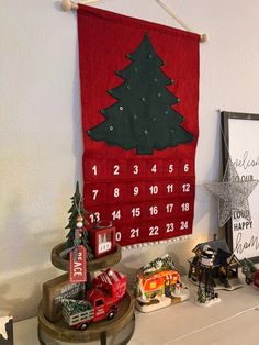 a christmas tree is hanging on the wall next to a calendar and other holiday decorations