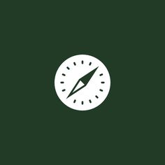 a white and green clock with a pen in it's center on a dark green background