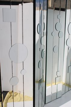 three glass doors with circular designs on the sides and round circles on the outside, all in different sizes