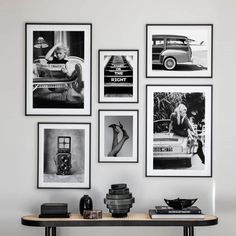 black and white photographs hang on the wall above a table