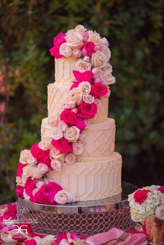 a wedding cake decorated with pink and white flowers