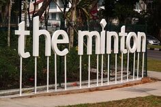 a sign that says the mintton on it in front of some trees and bushes