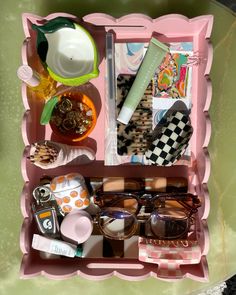 an open pink box with various items in it