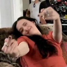 a woman laying on top of a couch holding a wine glass in her right hand