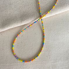 These bright necklaces are made with rainbow seed beads in a randomized pattern, meaning each is unique. They are very dainty and can add a fun but subtle touch to your outfits! Each is handmade with love :) Necklace Length: This necklace is available in lengths of 14, 15, 16, and 18 and inches. If you would like me to add an extender chain on the end of the necklace, please let me know in the personalization box! Note on shipping: The standard shipping for domestic orders is through oversized l Multicolor Letter Beads Necklace For Festival, Trendy Colorful Necklace With Tiny Beads, Rainbow Necklaces With Heart-shaped Beads, Playful Necklaces With Round Beads For Festivals, Playful Round Beads Necklaces For Festivals, Playful Festival Necklaces With Round Beads, Multicolor Heart Beads Necklace For Festivals, Rainbow Letter Beads Necklace For Festivals, Playful Round Beads Necklace For Festivals