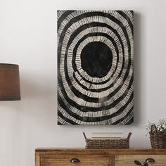 a black and white painting sitting on top of a wooden dresser