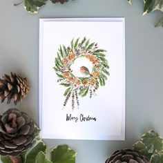 a christmas card with pine cones, holly and a bird on it's head