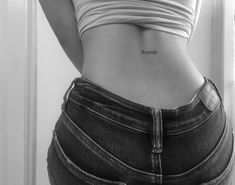 black and white photo of woman's stomach with small tattoos on her lower back