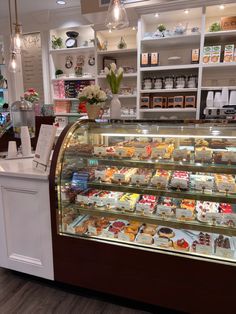 a display case filled with lots of different types of cakes and pastries in a store