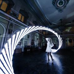 a woman standing in a room with an arch shaped like a bird's wing