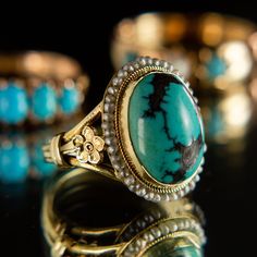 Description This beautiful, intricately crafted ring features a striking turquoise cabochon surrounded with a halo of delicate seed pearls. Buttery and vibrant 14k yellow gold brings out the stones' gorgeous natural hues of turquoise and cream, lending a bright, ethereal quality to this beautiful ring. Featuring a handcarved floral detail on each shoulder, this lovely piece is ready to live another lifetime with you. 14k yellow gold Natural Turquoise Cultured freshwater seed pearls The stone mea Pearl Halo Ring, Another Lifetime, Pearl Halo, Bespoke Jewellery, Seed Pearl, Jewelry Repair, Dream Ring, Beautiful Ring, Halo Ring