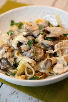 a white bowl filled with pasta covered in mushrooms